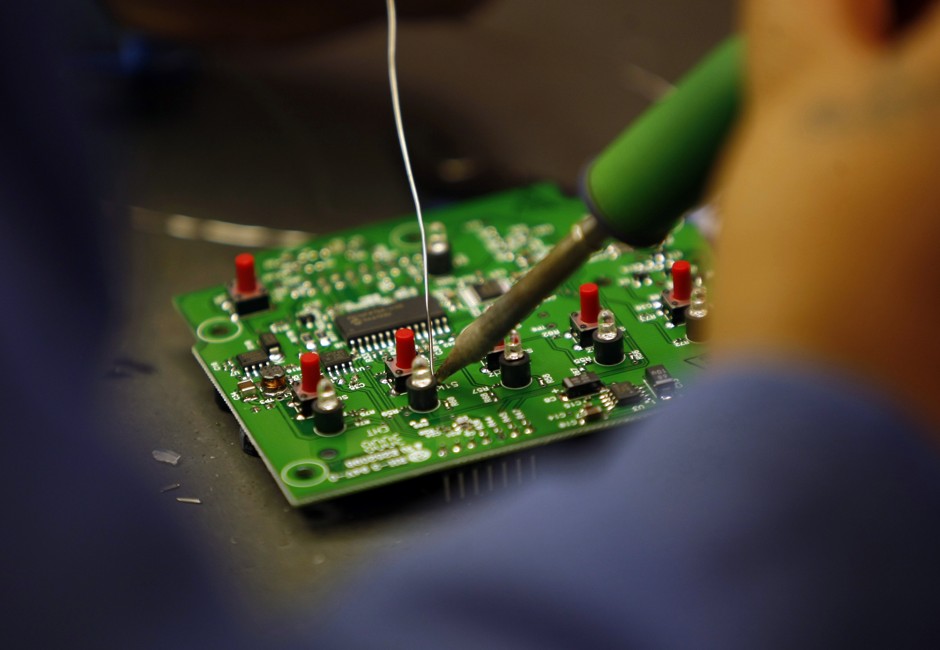 A worker solders a circuit board at the manufacturing facility of VAS, an electronics manufacturer in San Diego, California.