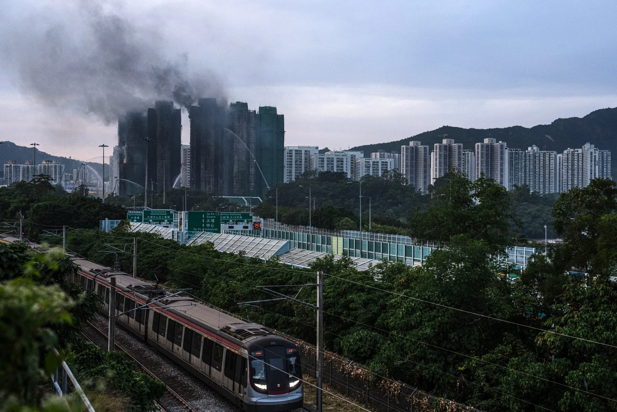 Smoke rises from buildings as fires continue to burn at the Wang Fuk Court residential estate in Tai Po district in Hong Kong, China, on Thursday, Nov. 27, 2025. Hong Kong’s deadliest fire in more than half a century killed at least 55 and destroyed hundreds of homes, throwing scrutiny on the city’s construction standards and raising questions of criminal accountability.