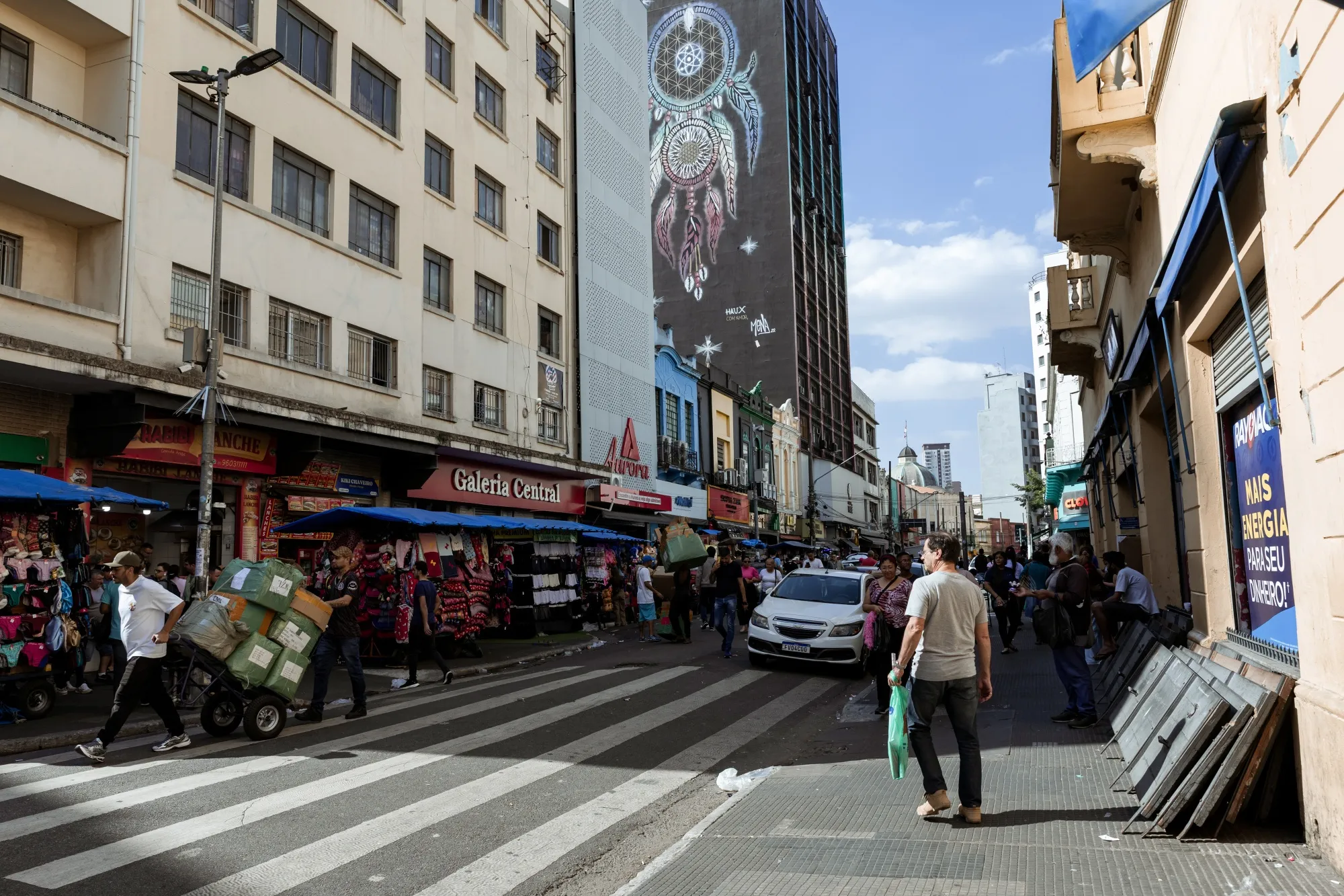 Shoppers pass retail stores on 25 de Marco Street in Sao Paulo, Brazil.