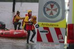 In this photo provided by the State Emergency Service, surf lifesaver Lee Archer carries a baby as the child and the mother are rescued from flood waters in Bulga, Australia, Wednesday, July, 6, 2022. Floodwaters were receding in Sydney and its surrounds on Thursday, July 7, 2022, as heavy rain continued to threaten to inundate towns north of Australia's largest city. (State Emergency Service via AP)