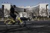 A man rides a bicycle past the People\'s Bank of China (PBOC) headquarters in Beijing, China, on Thursday, March 9, 2017. China\'s central bank plans to apply a stricter method for assessing banks\' capital as part of efforts to contain financial-sector risks, people with knowledge of the matter said.