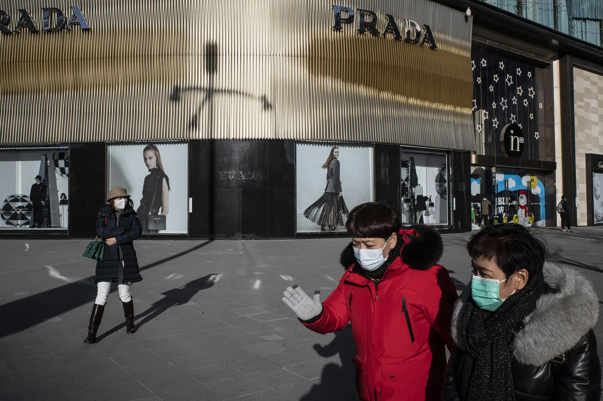 Pedestrians walk past luxury stores in the Wangfujing shopping area of Beijing.&nbsp;