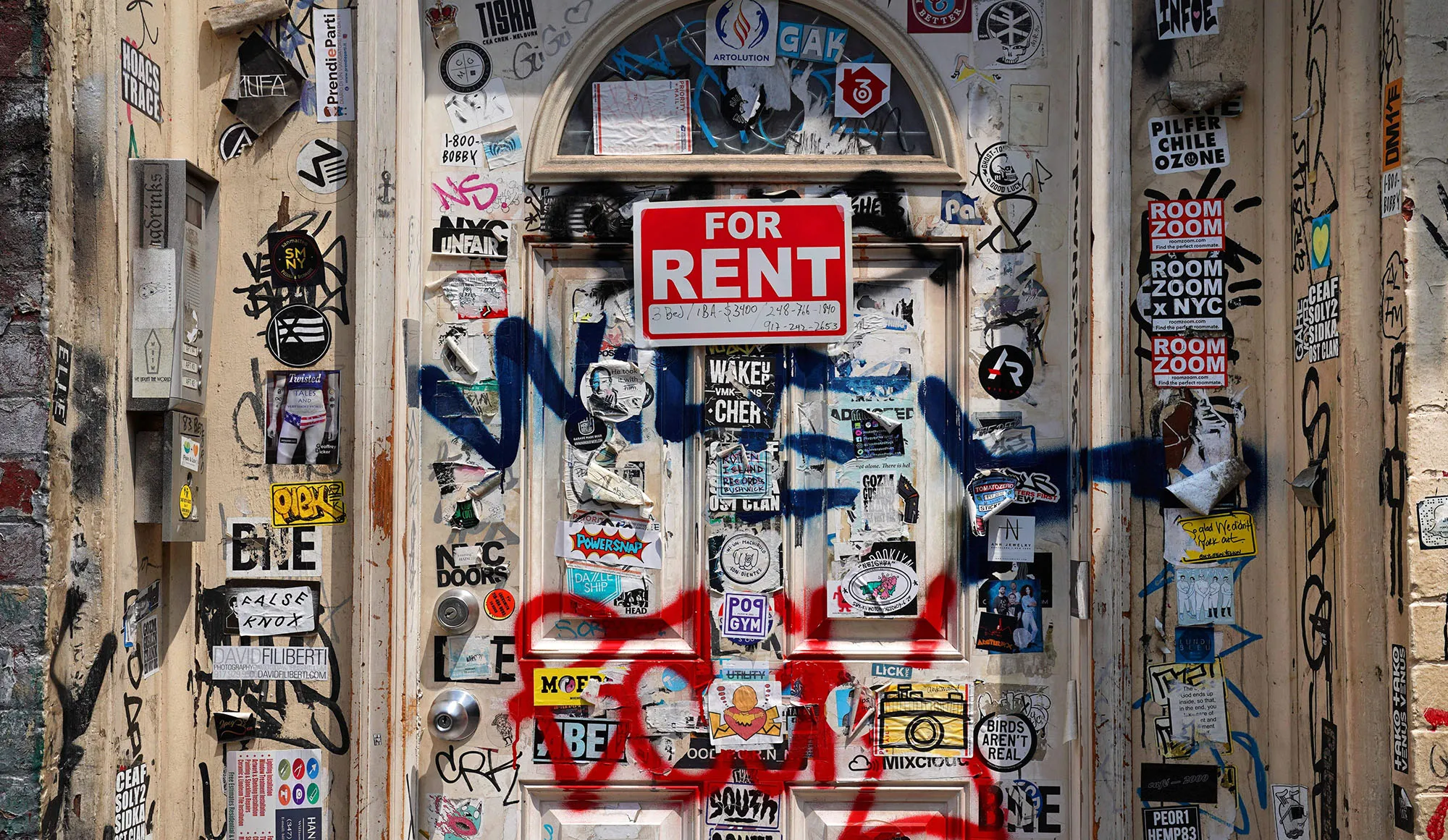 A "For Rent" sign on a graffiti filled door in&nbsp;Brooklyn, New York.&nbsp;