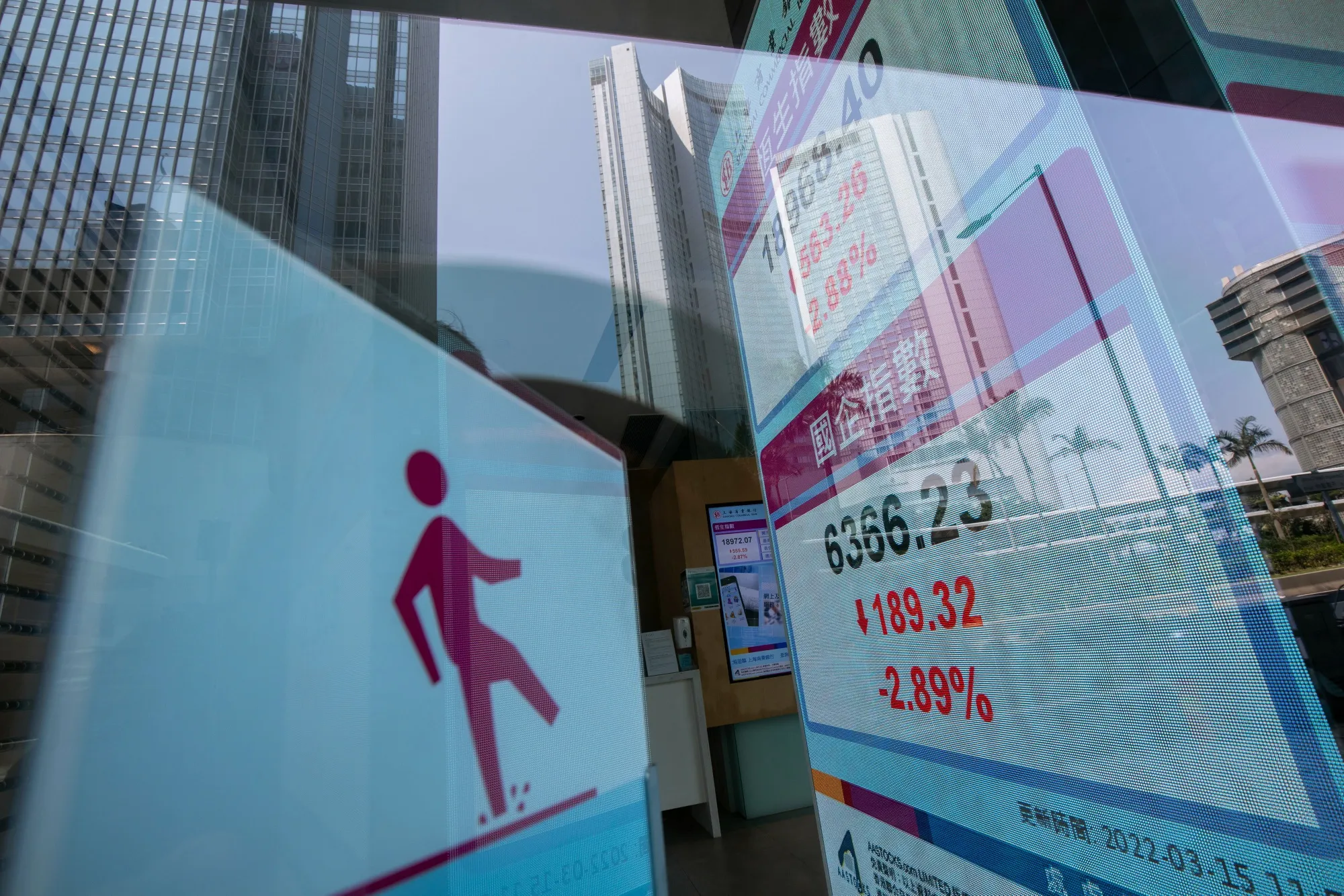 An electronic screen displays the Hang Seng Index, top, and Hang Seng China Enterprises Index, in Hong Kong.
