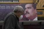 A pedestrian passes by a billboard featuring an image of Maduro in Caracas on April 9.