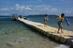 Tourists walk along a floating pier after snorkeling in the sea of Ishigaki, Okinawa Prefecture, Japan.