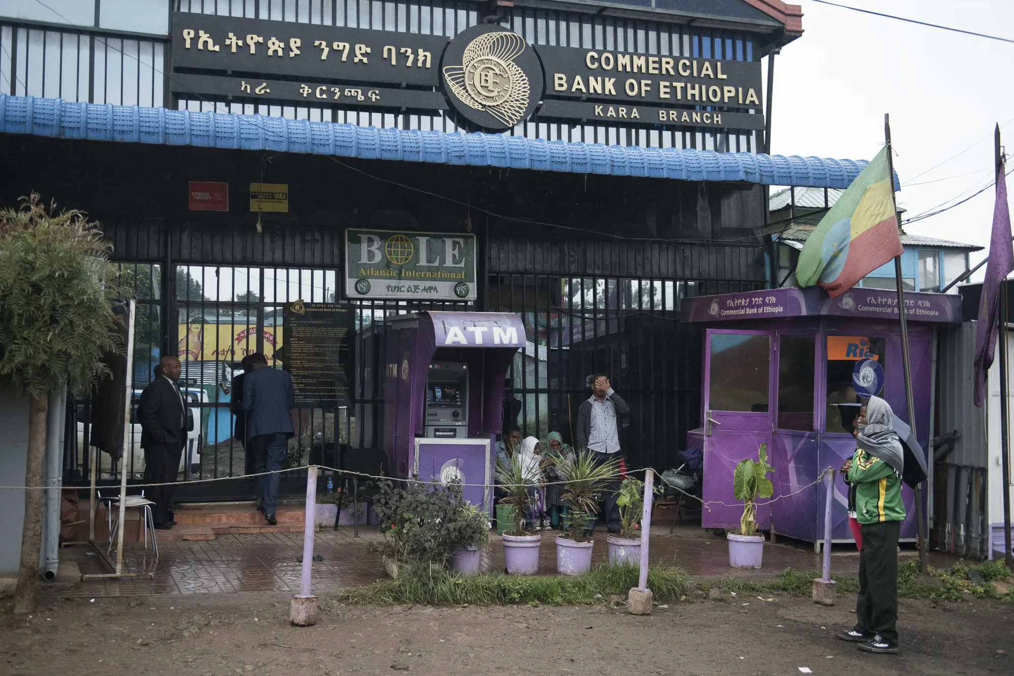 Pedestrians pass an automated teller machine operated by the Commercial Bank of Ethiopia in Addis Ababa, Ethiopia.