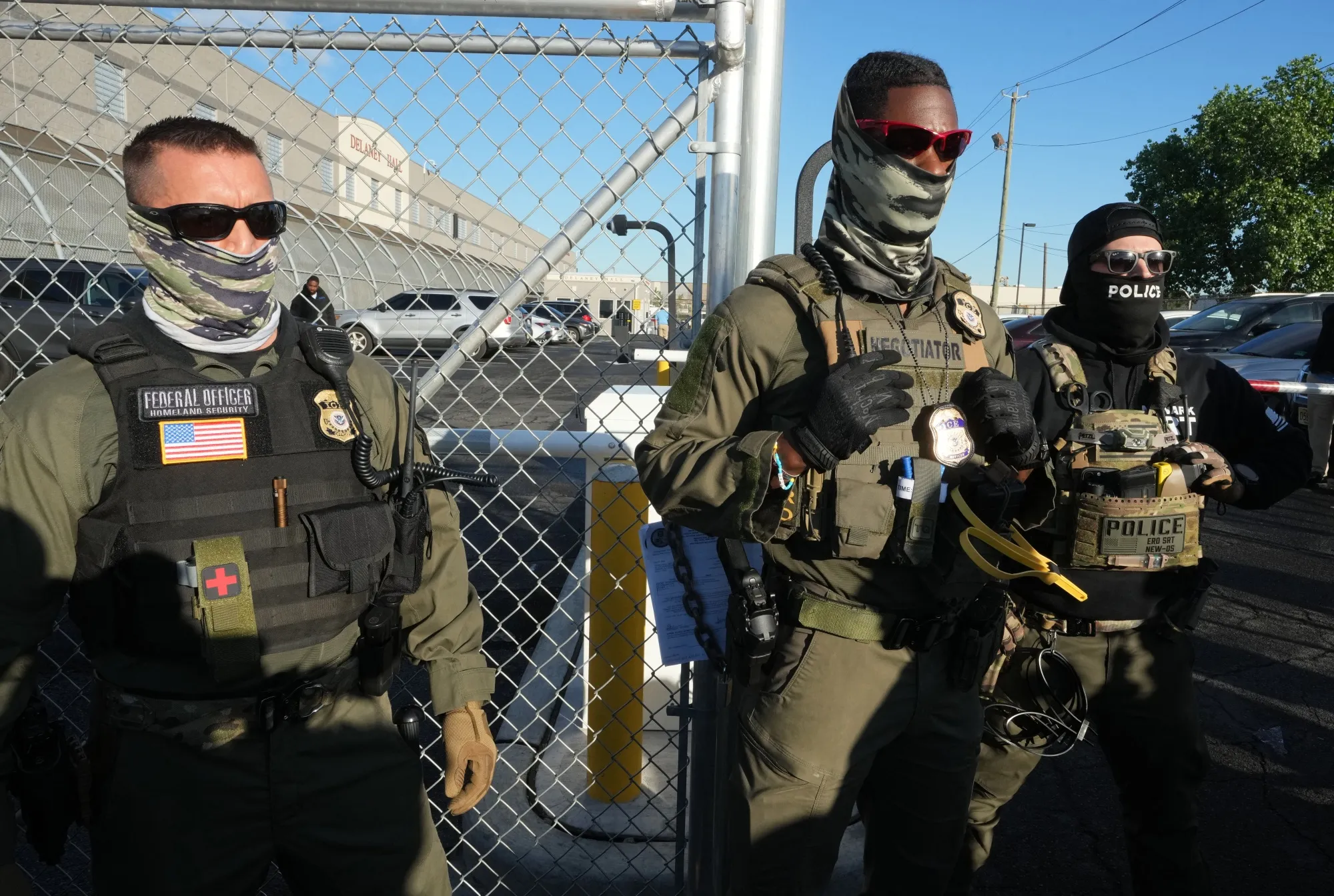 Immigration and Customs Enforcement (ICE) agents stand near a gate at Delaney Hall, an immigrant detention centre in Newark, New Jersey.