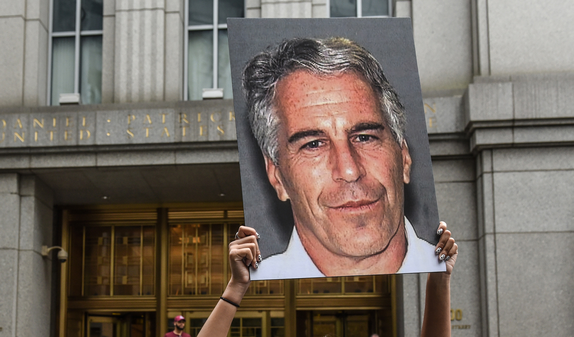 A protester holds up a sign of Jeffrey Epstein in front of the federal courthouse in New York in&nbsp;2019.