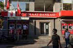 Pedestrians pass a bank branch of TC Ziraat Bankasi AS in Istanbul, Turkey.