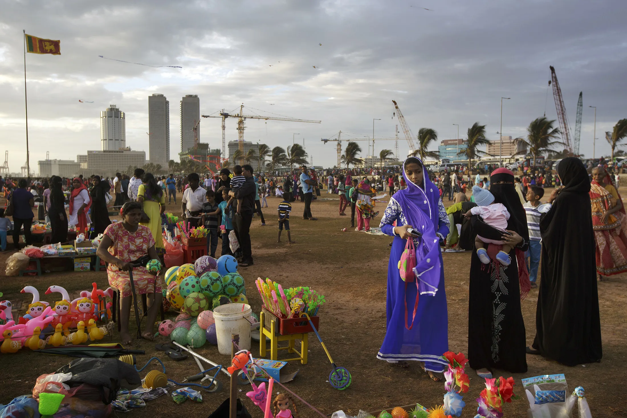 People gather on Galle Face Green as commercial buildings in the central business district stand in the background in Colombo, Sri Lanka.
