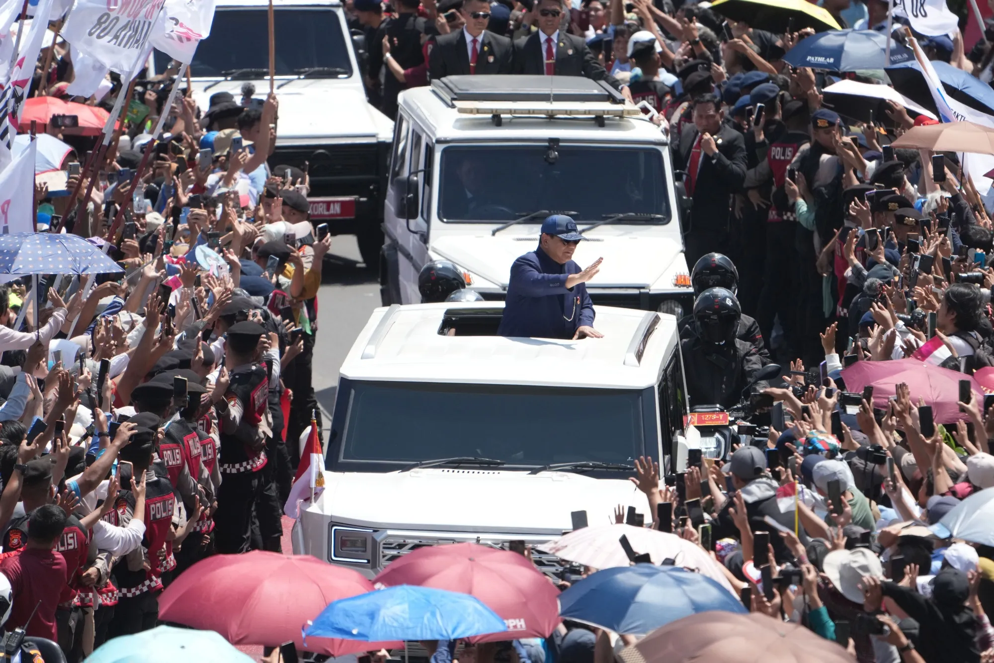 Prabowo Subianto waves to supporters during a parade in Jakarta on Sunday, Oct. 20, 2024.