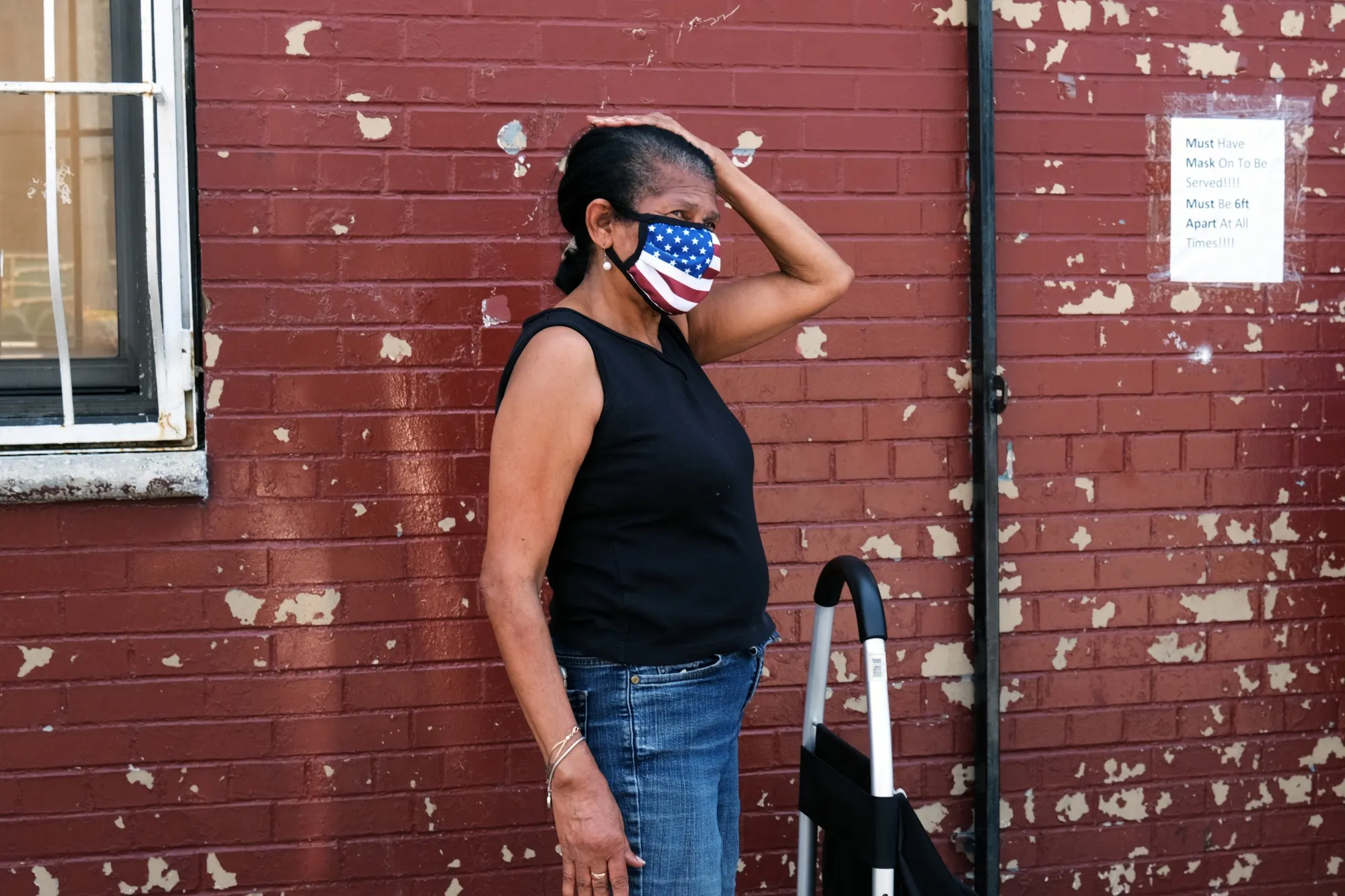 A woman waits in line as food is distributed at the Ebenezer Seventh-day Adventist church on July 22, 2020 in the Brooklyn borough of New York City.&nbsp;