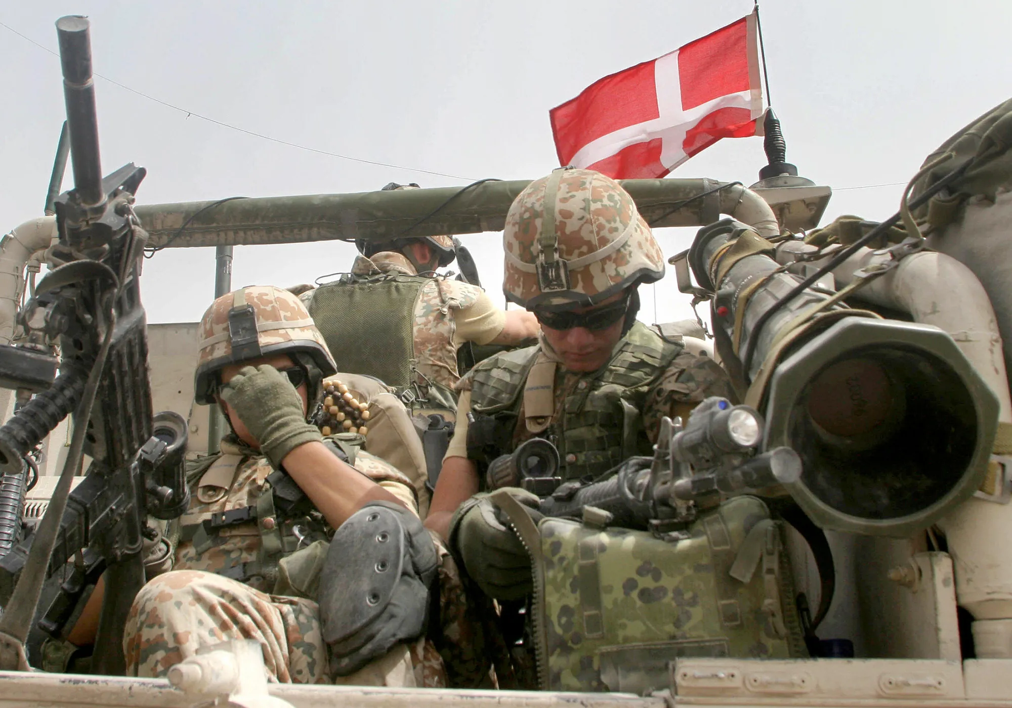 Danish soldiers rest in the back of a vehicle as they accompany a group of British Challenger-2 tanks of the Queen's Royal Hussars as it rolls into Basra 24 August 2006.
