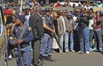 Armed police stand guard outside Estcourt's magistrates court Monday, Aug. 21, 2017 where crowds gathered following the brief court appearance of men accused of killing and eating human flesh.
