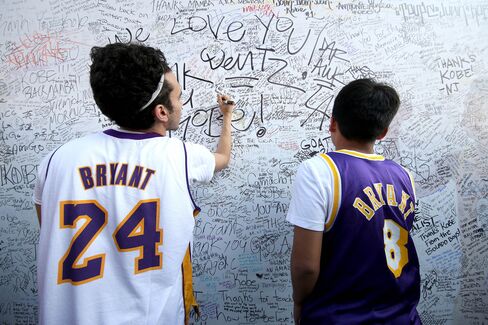 Fans sign an autograph board outside the Staples Center.
