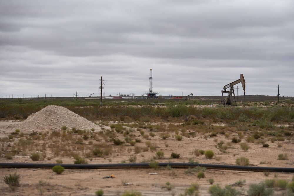 A horizontal drilling rig and a pump jack in Lea County, New Mexico.