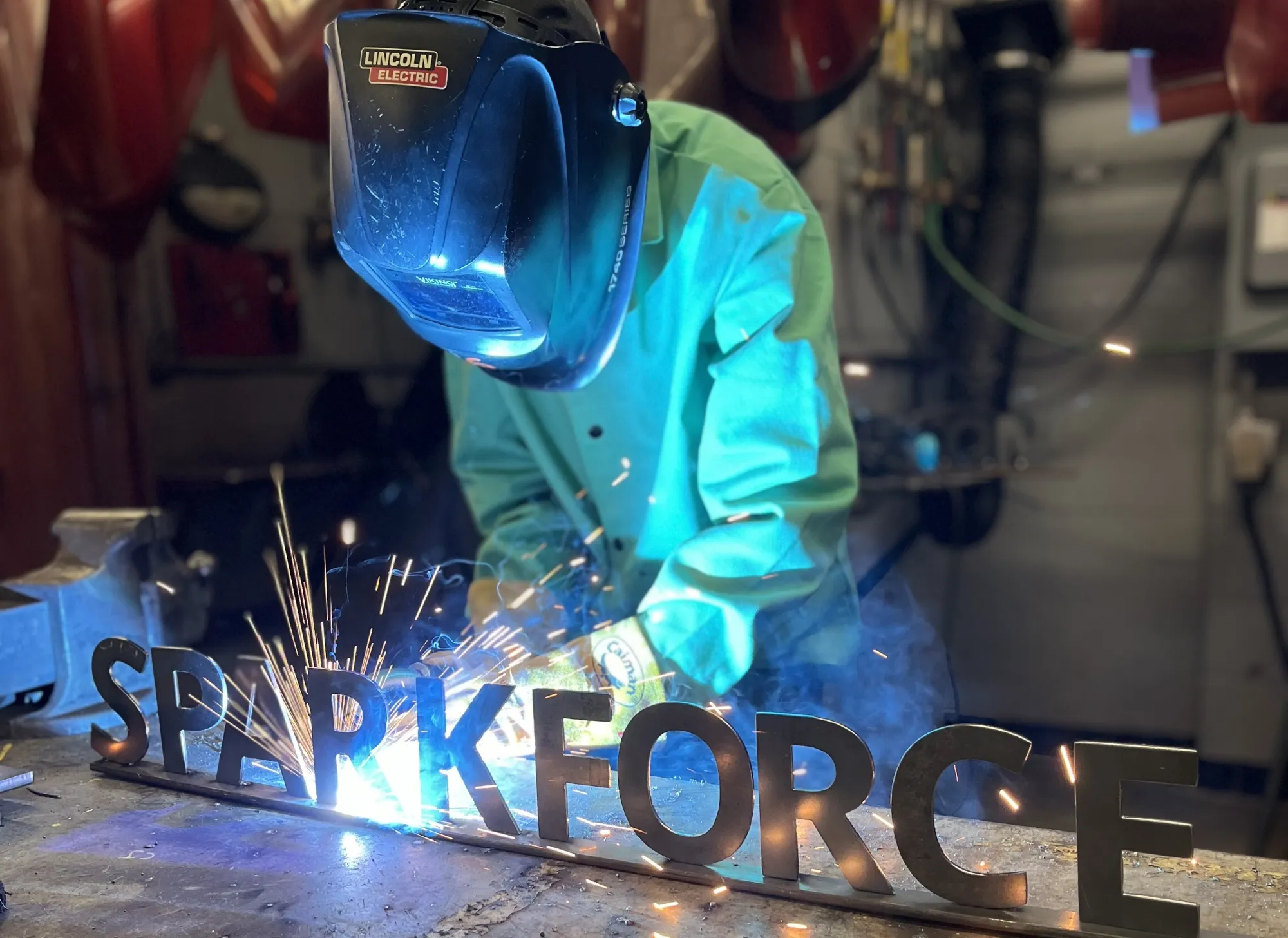 A camper in protective gear welds a metal SparkForce sign at a Salem City Schools Welding Camp in Salem, Virginia, in July. 