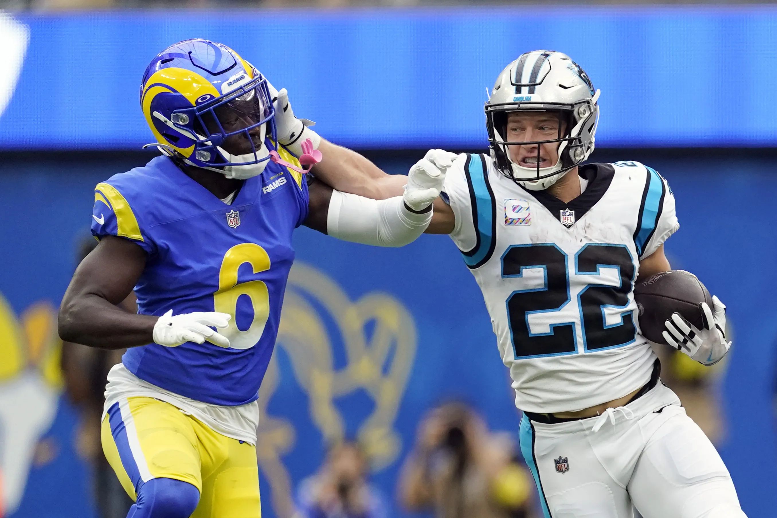 Carolina Panthers running back Christian McCaffrey (22) stiff-arms Los Angeles Rams cornerback Derion Kendrick (6) during the first half of an NFL football game Sunday, Oct. 16, 2022, in Inglewood, Calif. (AP Photo/Ashley Landis)