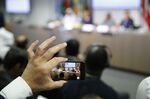 An attendee uses a mobile device to videotape a news conference following the 176th Organization Of Petroleum Exporting Countries (OPEC) meeting in Vienna, Austria, on Monday, July 1, 2019. 