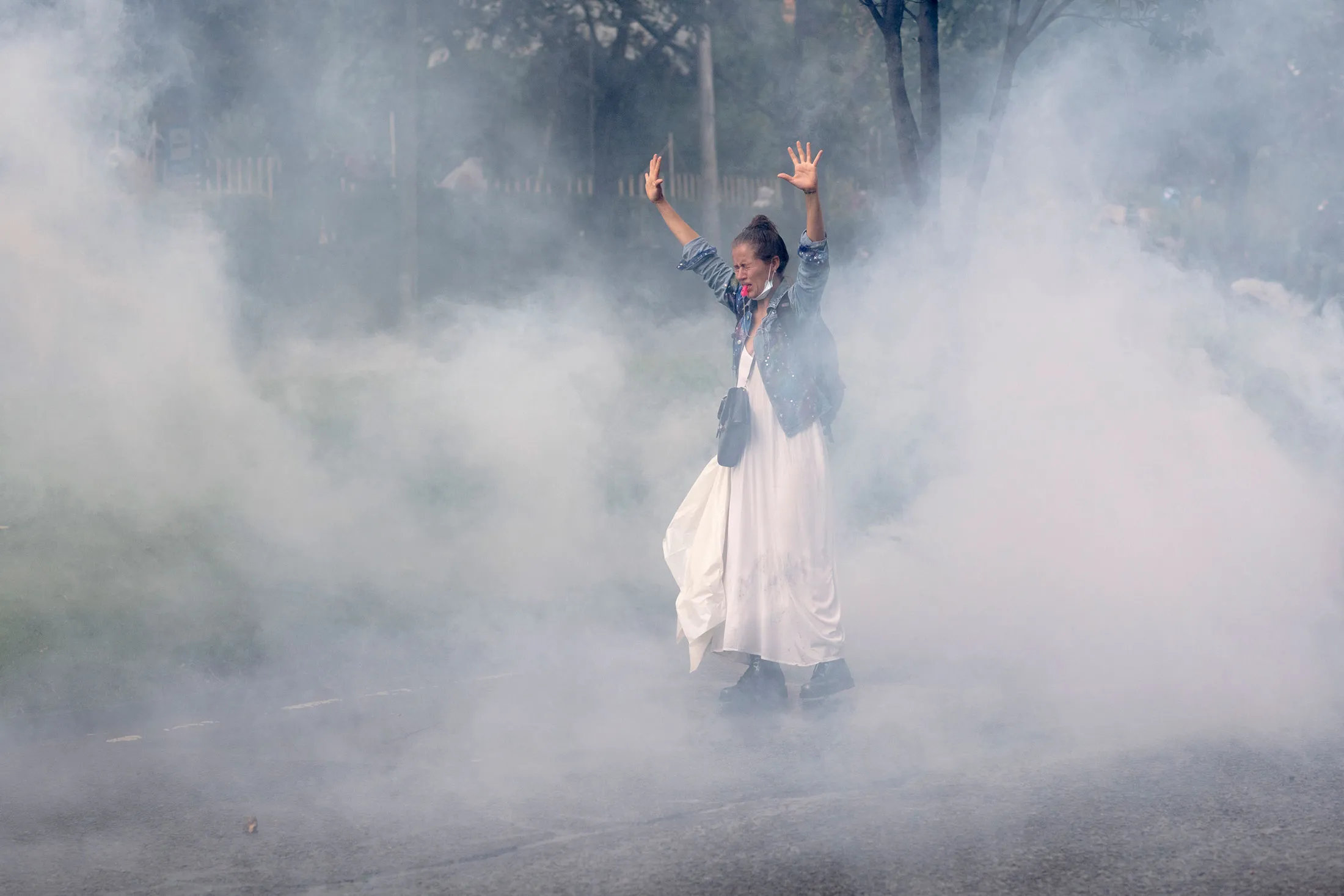 A demonstrator stops in the middle of tear gas for several seconds, refusing to leave, to show her determination in Bogotá on May 1.