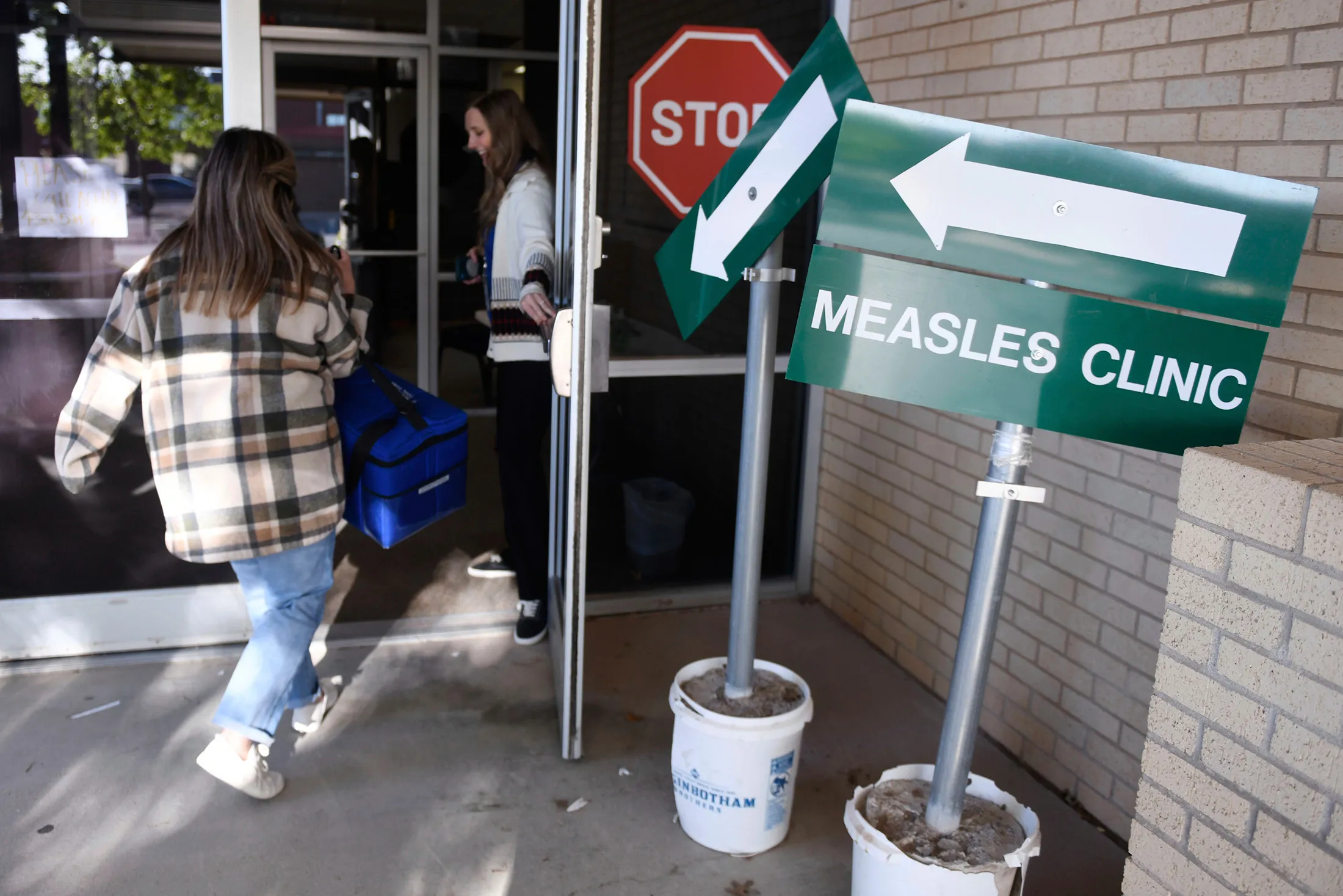 Health department staff members enter the Andrews County Health Department measles clinic in Andrews, Texas, on April 8.