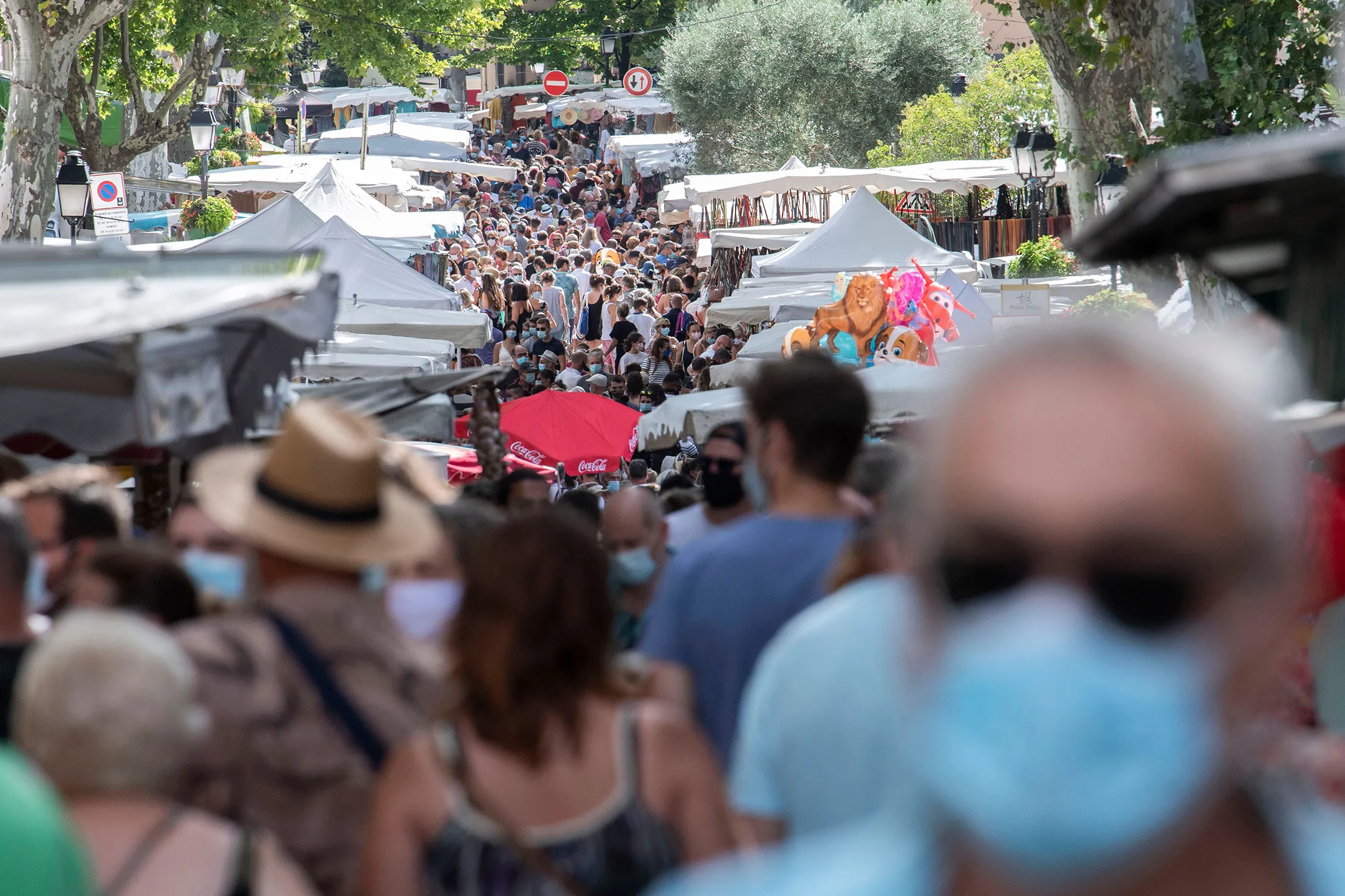People walk in a congested street market of Lourges, southern France on Aug. 18.