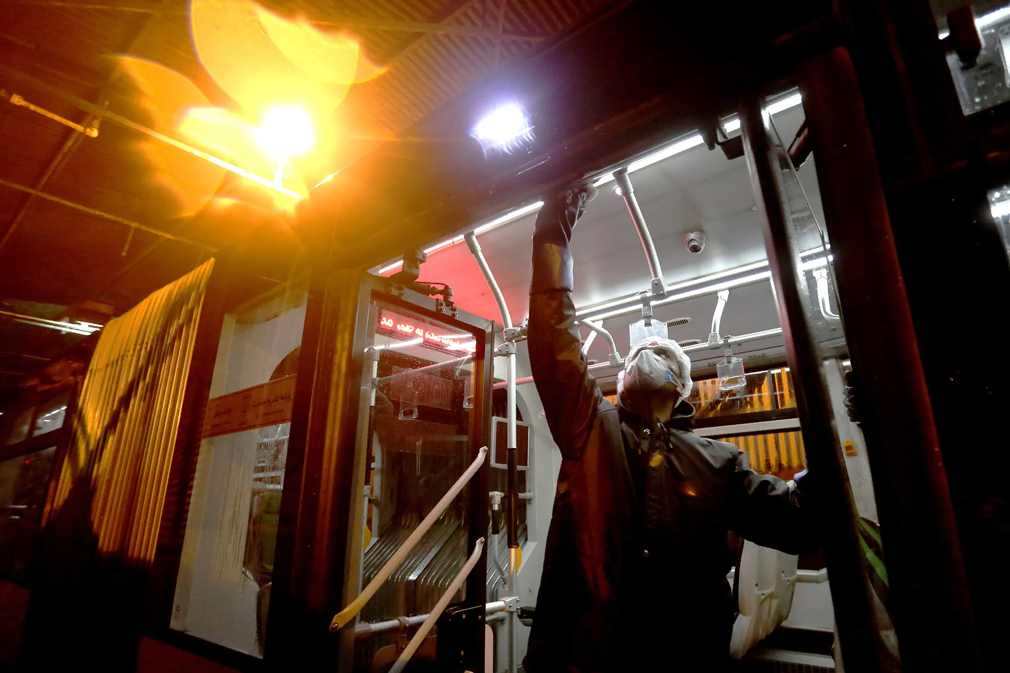 A Tehran Municipality worker cleans a bus to avoid the spread of the virus.&nbsp;