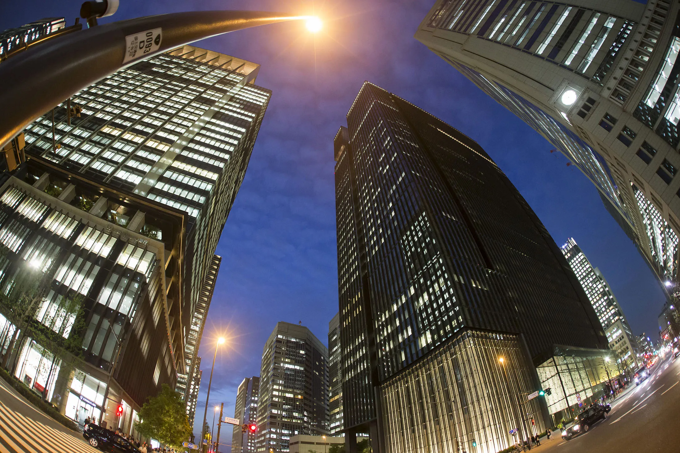 The Mizuho Financial Group Inc. headquarters, center right, stands at dusk in this photograph taken with a fish-eye lens in Tokyo, Japan, on Friday, April 21, 2017.