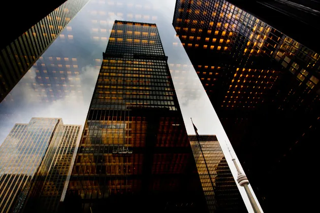 Bank towers are reflected in a window at the financial district of Toronto, Ontario, Canada