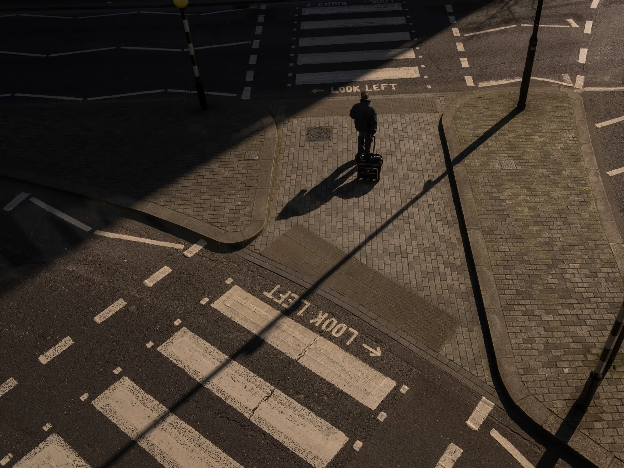 A pedestrian crosses an empty street in London.
