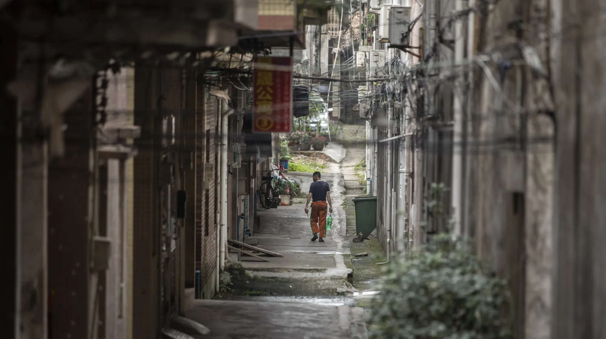 A man walks down an alley near a cluster of small factories in Dongguan, China.