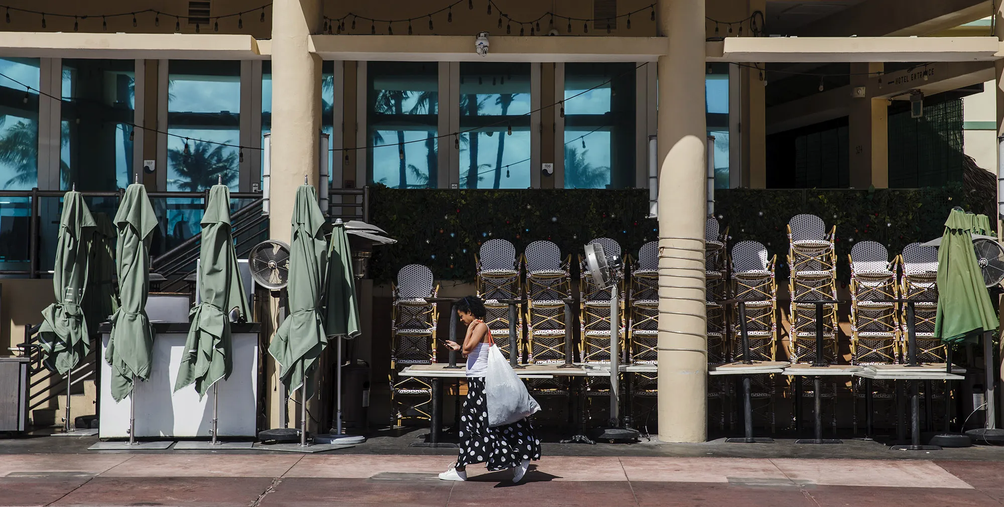 A pedestrian passes in front of a closed restaurant in the South Beach neighborhood of Miami Beach on March 20.