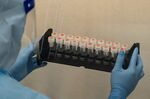 A lab technician wearing protective suit handles saliva samples for Covid-19 testing at a laboratory in Hong Kong.