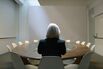 Woman seated in boardroom from behind
