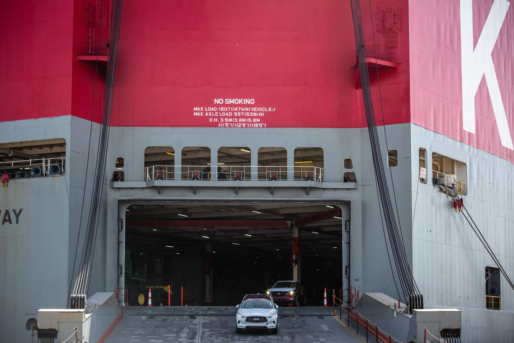 Vehicles drive off a Kawasaki Kisen Kaisha cargo ship in Barcelona.