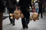 A man carries live chickens that he bought at a market in Guangzhou, southern China’s Guangdong province.