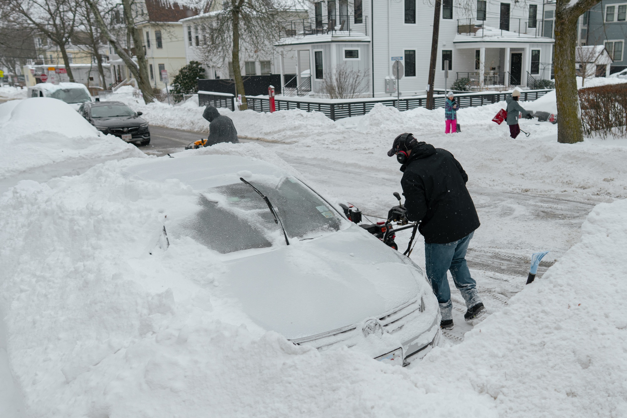 A resident clears snow surrounding a vehicle in Somerville, Massachusetts, US, on Monday, Jan. 26, 2026. US power grids are expected to grapple with unprecedented seasonal demand and the threat of blackouts after a damaging winter storm coated parts of the South and Mid-Atlantic in ice - leaving brutal cold in its wake. Photographer: Mel Musto/Bloomberg