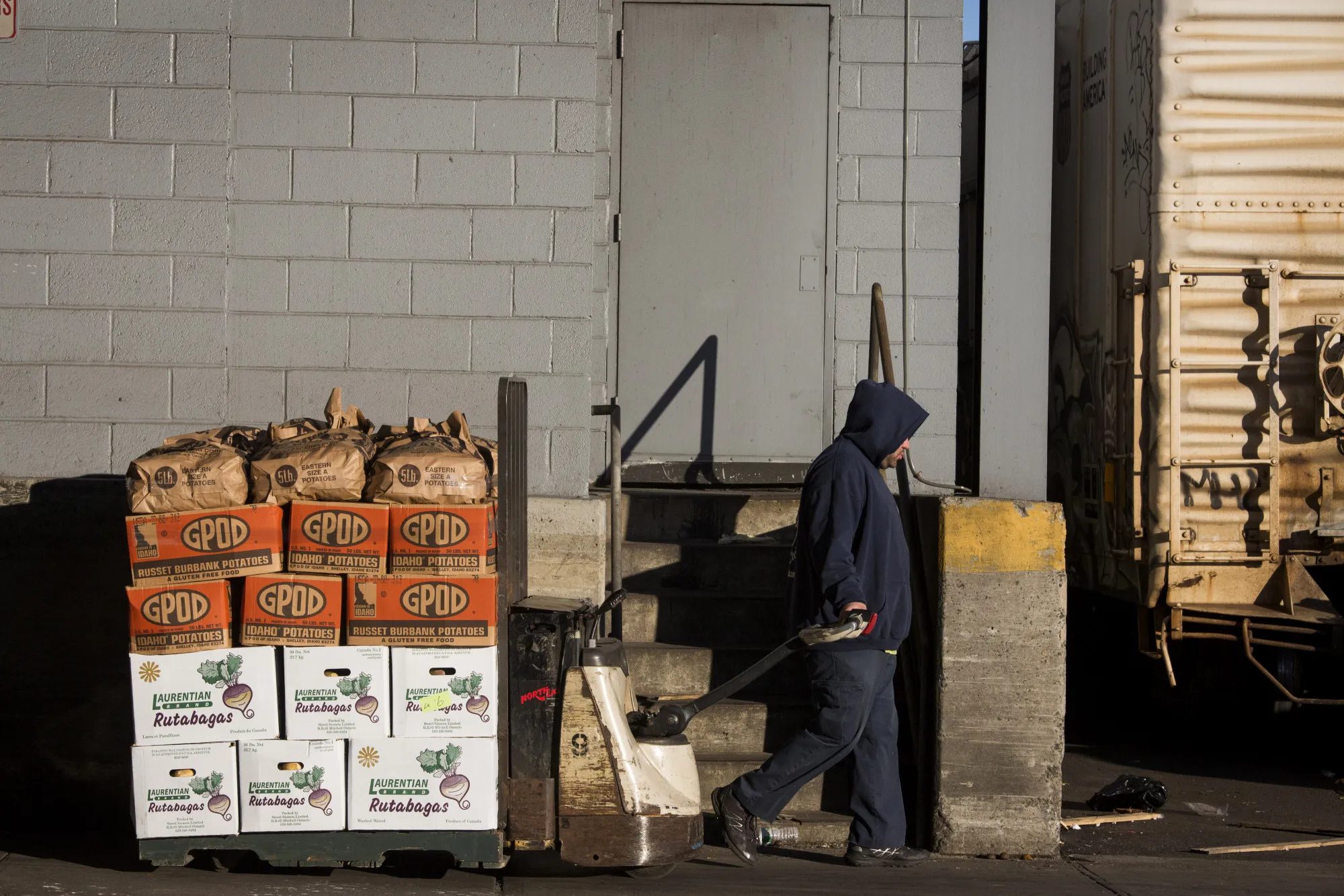 A worker moves produce from refrigerator rooms to trucks for transport at the Hunts Point Terminal Produce Market in the Bronx borough of New York, U.S.