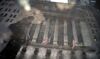 A pedestrian carrying an umbrella is reflected in a puddle in front of the New York Stock Exchange.