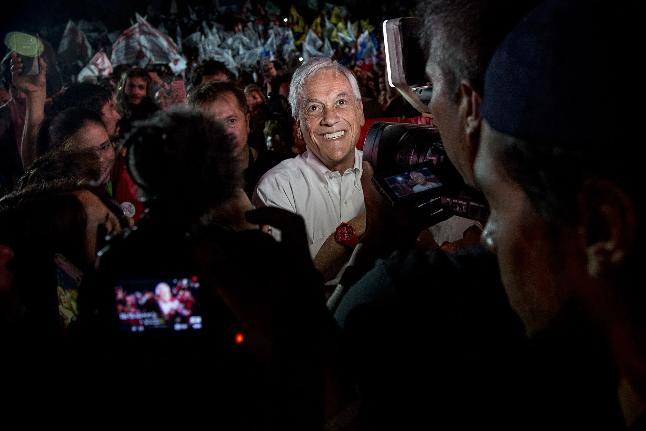 Members of the media take photographs of presidential candidate Sebastian Pinera as he stands with supporters during a campaign rally in Santiago, Chile.