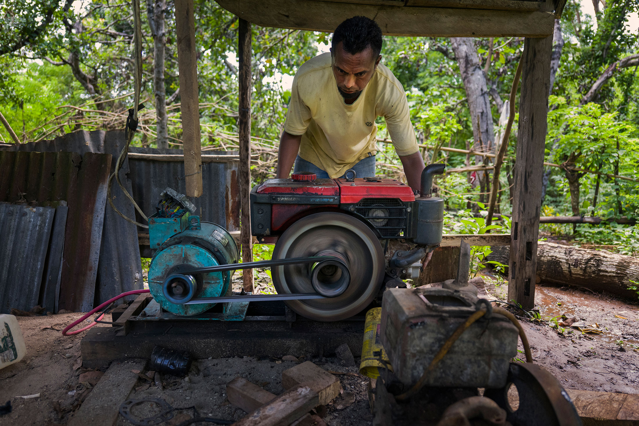 Amos Kaliukur (37) turns on a diesel generator powering his carpentry workshop in Prai Witu village, East Sumba, Indonesia on February 16, 2022.