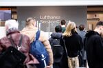 Passengers wait at a Lufthansa information desk following the grounding of flights, at Munich Airport on Feb. 15.