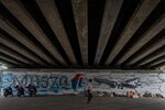 An unidentified man walks past MH370 related street art under a flyover in Kuala Lumpur, Malaysia.
