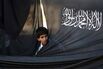A Palestinian boy looks through the flag of Hizb ut-Tahrir, or Party of Liberation, during a rally in the West Bank city of Ramallah.