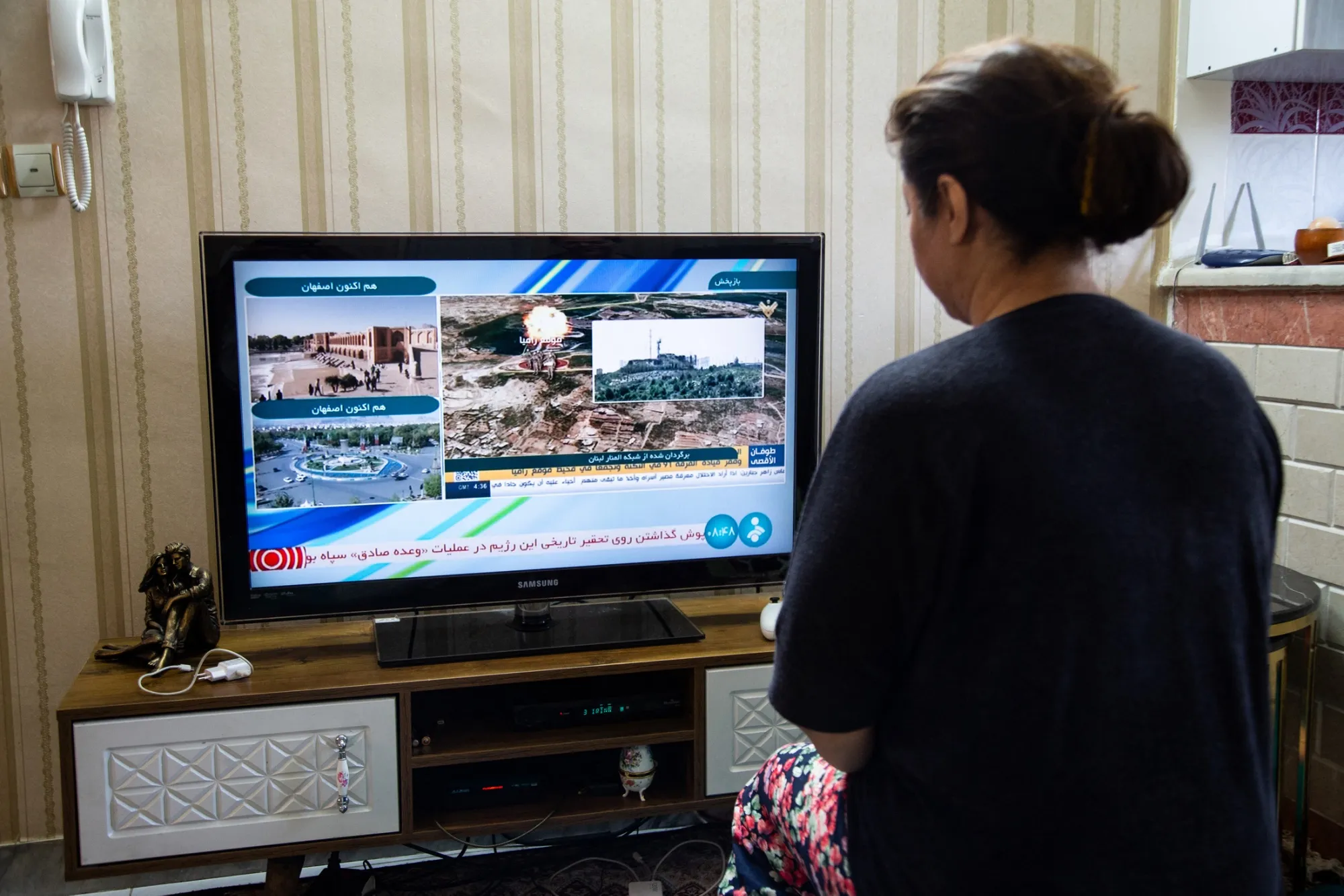 A woman watches a news broadcast in Tehran on April 19.