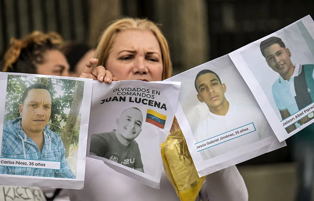 Una mujer muestra fotografías de presos políticos venezolanos durante una vigilia el 5 de agosto en Caracas.