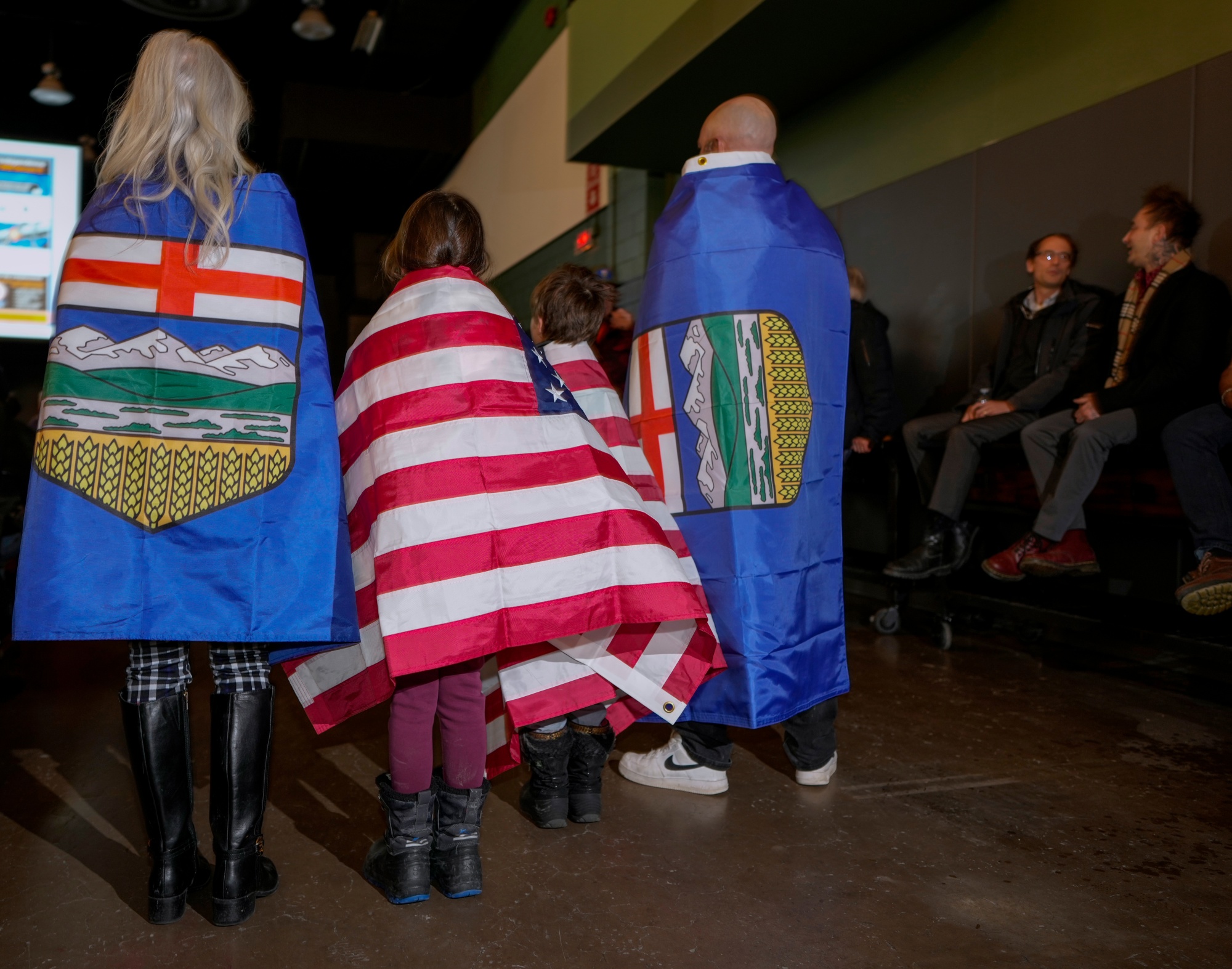 Attendees wear Alberta and American flags during the Alberta Independence Town Hall event in Calgary, Alberta, Canada, on Monday, Jan. 26, 2026. A petition has been started by separatist activists in Alberta for a referendum on independence from Canada, driven in part by a belief that the government in Ottawa hasn't done enough to accelerate projects to expand oil production, such as new pipelines. Photographer: Leah Hennel/Bloomberg