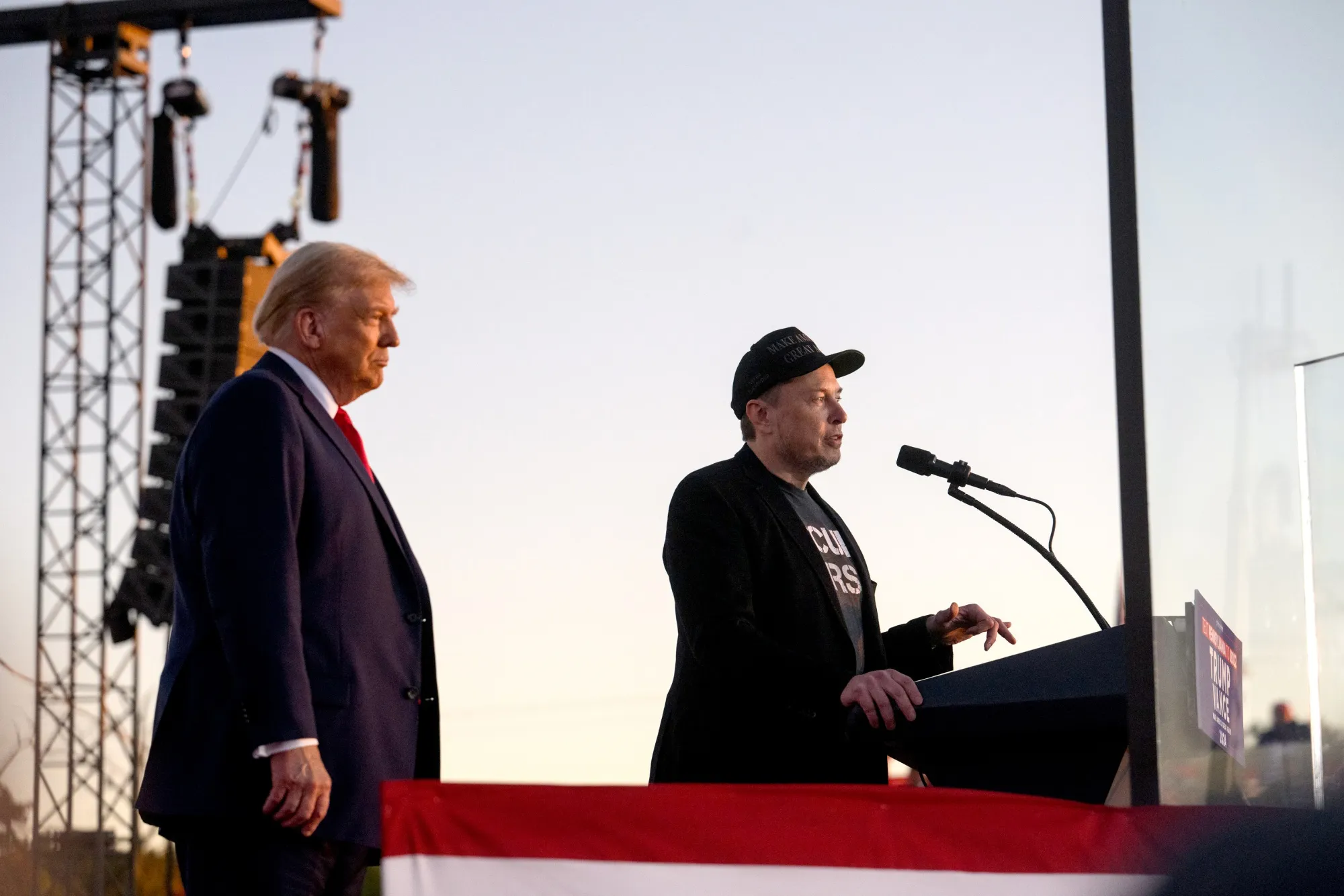 Elon Musk, right, speaks on stage with Donald Trump
