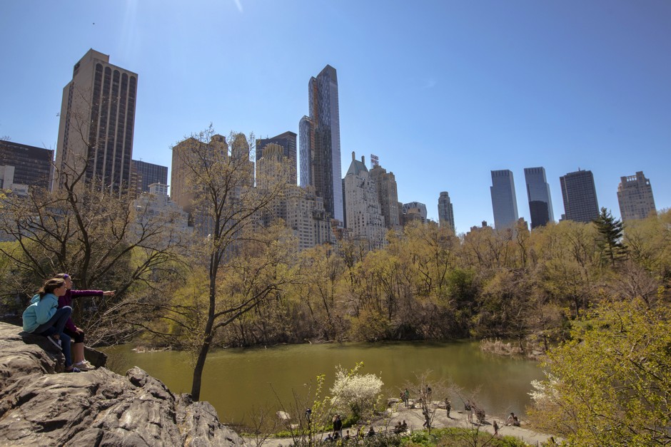 Park-goers enjoy the view of the Manhattan skyline from Central Park.
